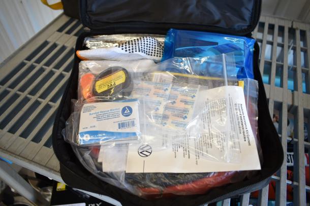 9 assorted first aid and roadside kits from Hyundai, Nissan, Genesis, Kia, and VW. Includes survival blanket, bandages.