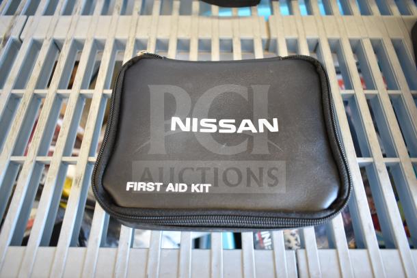 Nissan first aid kit in black case, zippered, displayed on gray surface, part of a lot with Hyundai/Nissan/Genesis/Kia kits.