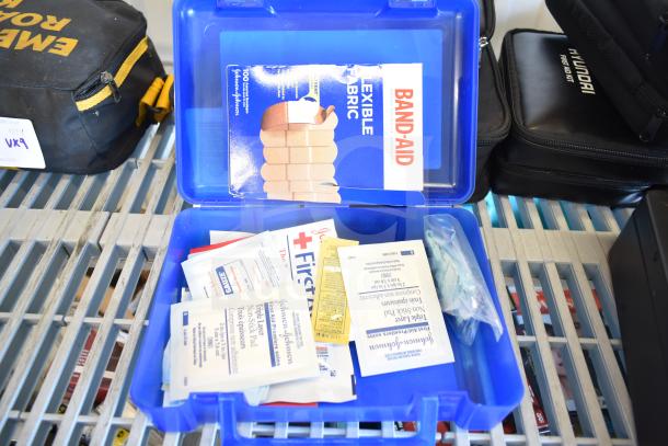 9 first aid and roadside kits including Hyundai, Nissan, Genesis, Kia first aid kits, and VW roadside assistance kit, various items included.