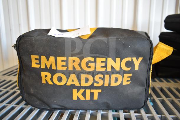 Black and yellow emergency roadside kit bag with visible wear, labeled "EMERGENCY ROADSIDE KIT." Part of a 9-item auction set.