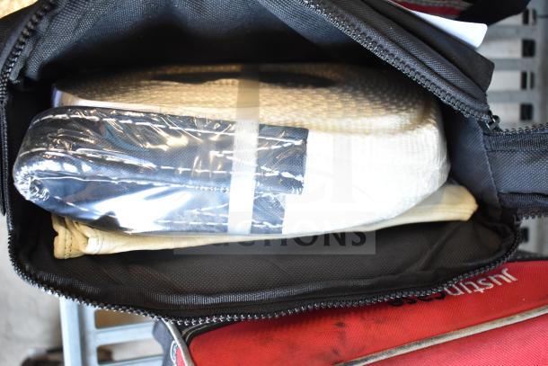 Three bags with contents, including jumper cables. Black and red bags, one with clear plastic-wrapped item.