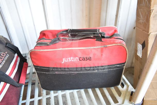 Red and black "Justin Case" bag with handles, signs of wear, contains jumper cables, part of auction lot.