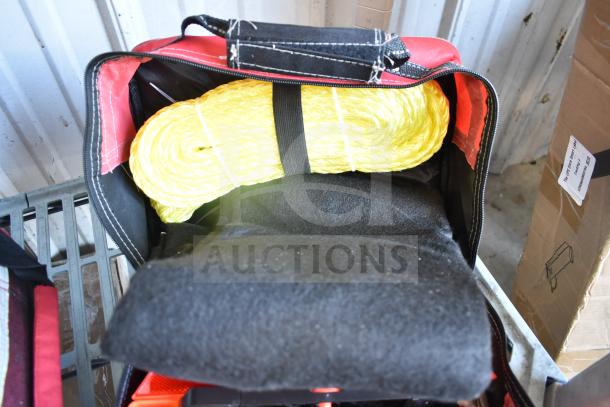 Black and red bag containing yellow rope and black fabric. Ideal for tools or emergency use.