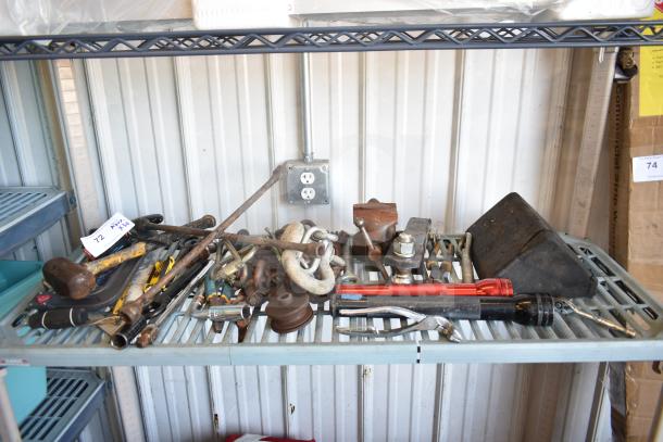 Assorted tools and items including flashlights, hitches, and wrenches on a shelf. Includes rusted and used conditions.