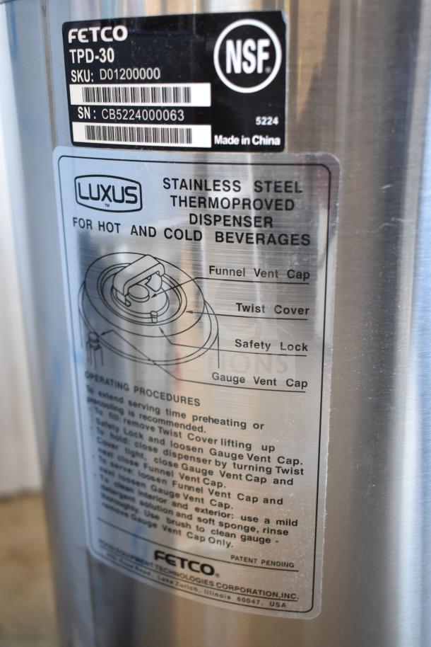 Stainless steel Fetco TPD-30, 3-gallon coffee dispenser, shows minor scratches; labeled as suitable for hot/cold drinks.