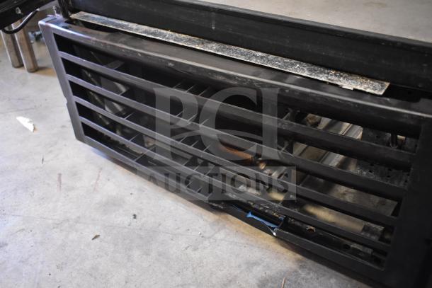 True GDM-26 commercial cooler base, showing vent grates and condenser area. Black finish, used condition. Model GDM-26.