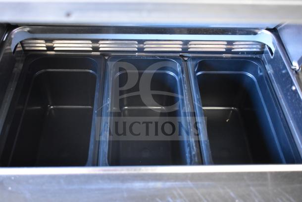Delfield UCD4464N-12-DD5 prep table interior with three black inserts, stainless steel finish, commercial kitchen equipment.