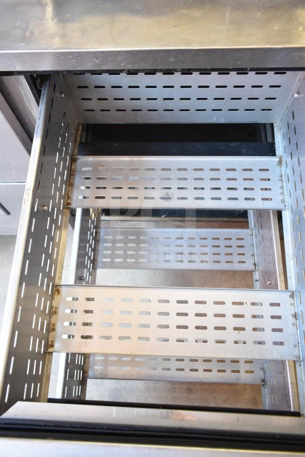 True TPP-93D-6 commercial pizza prep table, featuring open metal drawer design. Model TPP-93D-6, on casters.