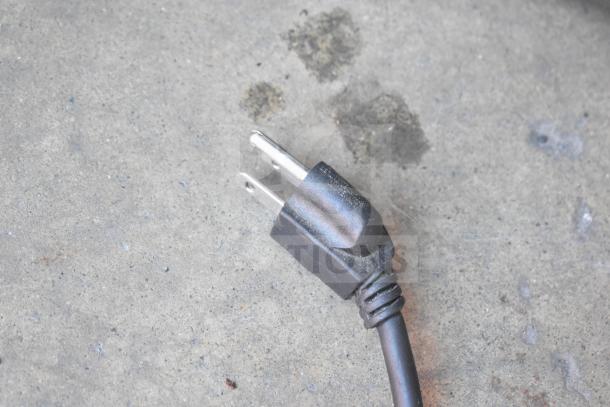 Black power cord for Carter Hoffmann MZ223G Heated Holding Cabinet; 120 Volts, 1 Phase. Visible plug on concrete surface.
