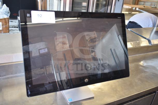 HP All In One Computer with black bezel and silver stand, reflective screen, auction tag 92 visible, in used condition.