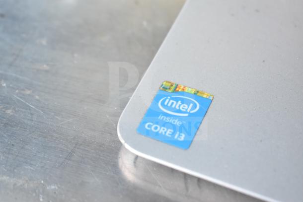 HP All In One Computer with Intel Core i3 sticker, highlighting processor type. Silver finish, detail on device's corner.