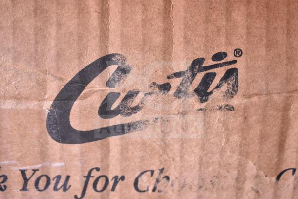 Cardboard box with Curtis logo. Contains Curtis GEM3IF 1.5 Gallon Satellite Coffee Server with IntelliFresh. Box shows wear.