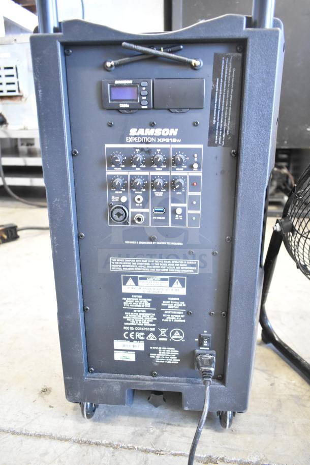 Samson Expedition XP312w Portable PA System, rear control panel view, with volume knobs, input ports, and power switch.