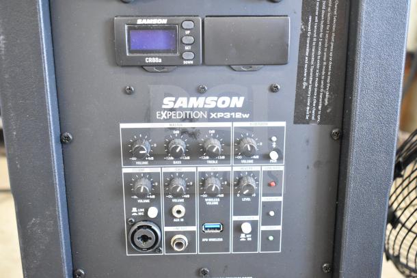 Samson Expedition XP312w Portable PA System with control panel and input options. Display shows wireless settings.