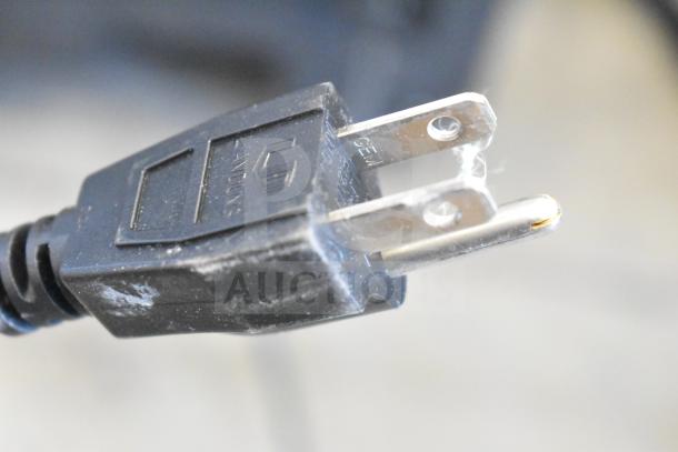 A close-up of a standard two-prong power plug for a Samson Expedition XP312w Portable PA System.