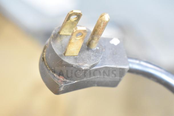 Close-up of a 115-volt power plug for a Beverage Air DP93 commercial pizza prep table, showing prongs and cable.