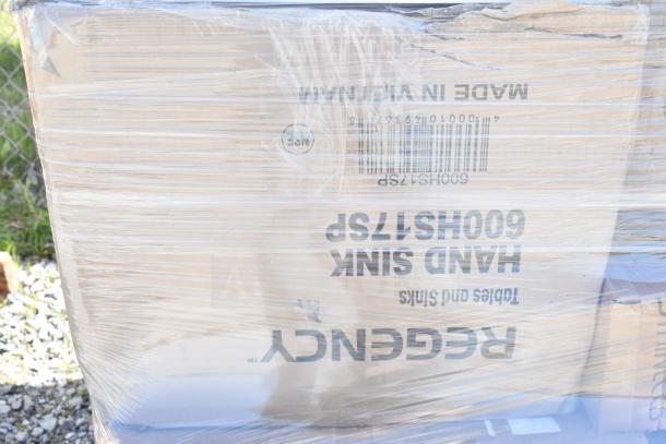 Plastic-wrapped pallet of brand new scratch and dent items including a Regency hand sink. Box barcode and markings visible.