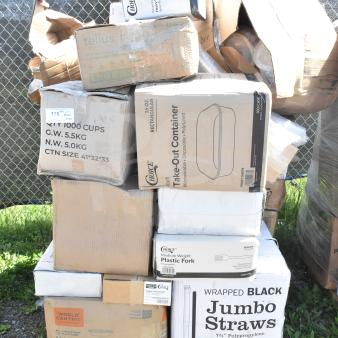 Pallet with boxes of brand new scratch and dent items including Choice teaspoons, take-out containers, and jumbo straws.