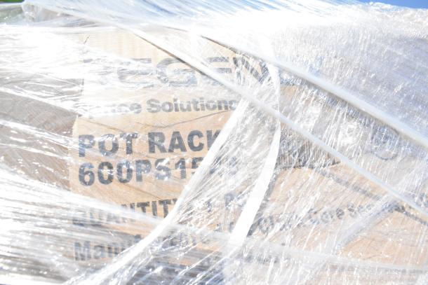 Plastic-wrapped item with visible label reading "Pot Rack, 600PS15." Item is part of a scratch and dent auction lot.