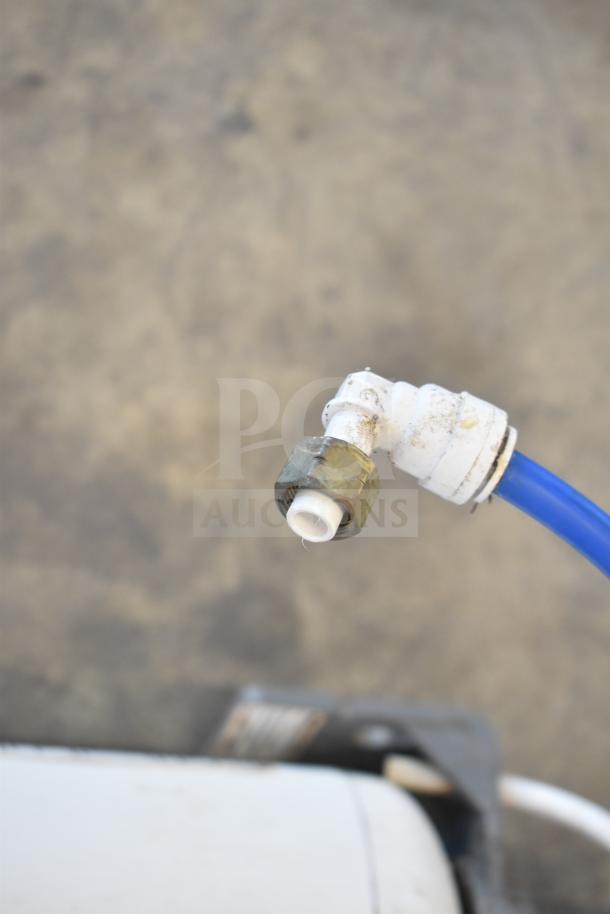 Water filtration system component with brass connector and blue tubing, showing signs of wear. Key part for filtration.