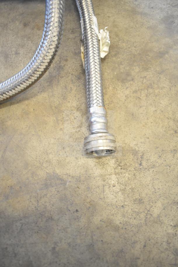 Braided stainless steel hose of a water filtration system, slight wear visible, metal connector end.