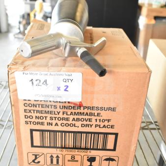 Box of butane fuel cans and whipped cream dispenser on warehouse shelf. Label: "Contents under pressure; flammable." Quantity x2.