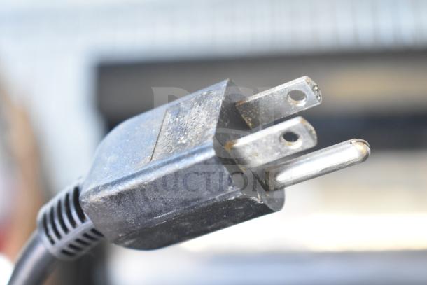 Close-up of a power plug. No visible DayMark 9700 Simple Food Prep Labeler features shown.