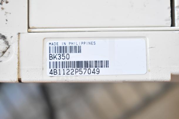 2 APC Back UPS CS 350 units, white, Model BK350, barcode 4B1122P57049, made in Philippines.