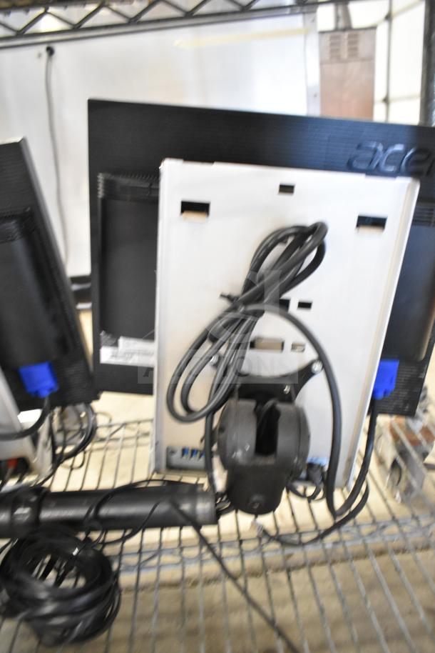 Two Acer monitors with an NCR Kitchen Controller, cables connected, on a metal shelf. Brand visible on monitor.