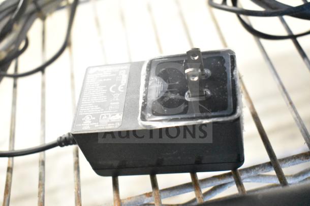 Power adapter with attached cable for Acer monitors, showing safety certifications and plug type.