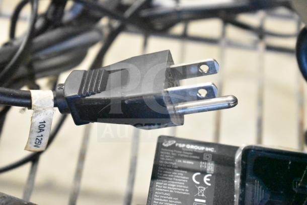 Power cord with 10A 125V label and plug next to NCR kitchen controller adapter from FSP Group Inc.