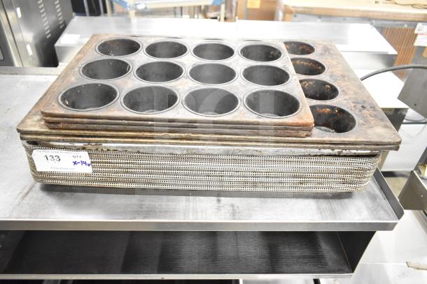 Stack of 14 assorted baking items including used mesh and muffin pans, visible auction tag indicates "133, QTY x14".