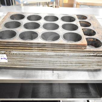 Stack of 14 assorted baking items including used mesh and muffin pans, visible auction tag indicates "133, QTY x14".