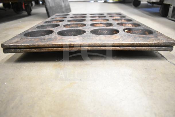 14 various baking pans, including mesh and muffin pans, stacked. Used condition with visible wear, auctioned as a set.
