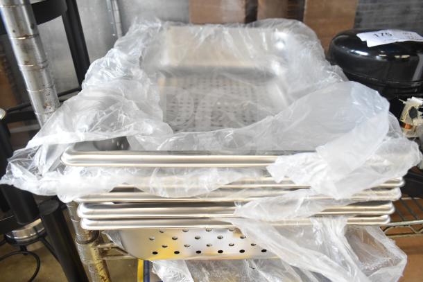 Stack of brand new stainless steel perforated drop-in bins, wrapped in plastic. Clean and unused condition.