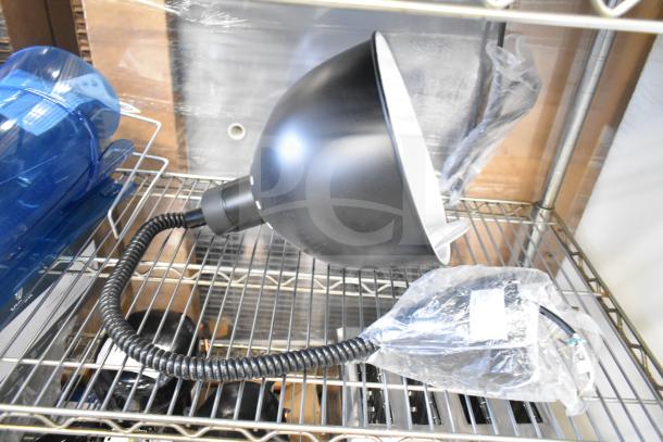 2 new ServIt HLR85BK heat lamps with black round dome shade, retractable cord, 120V, on shelf, packaging intact.