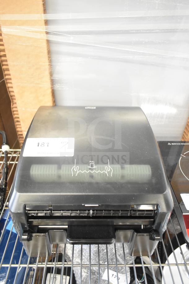 BRAND NEW Tork 772728 black mechanical paper towel dispenser with minor scratches and dents, model H71, retail tag visible.