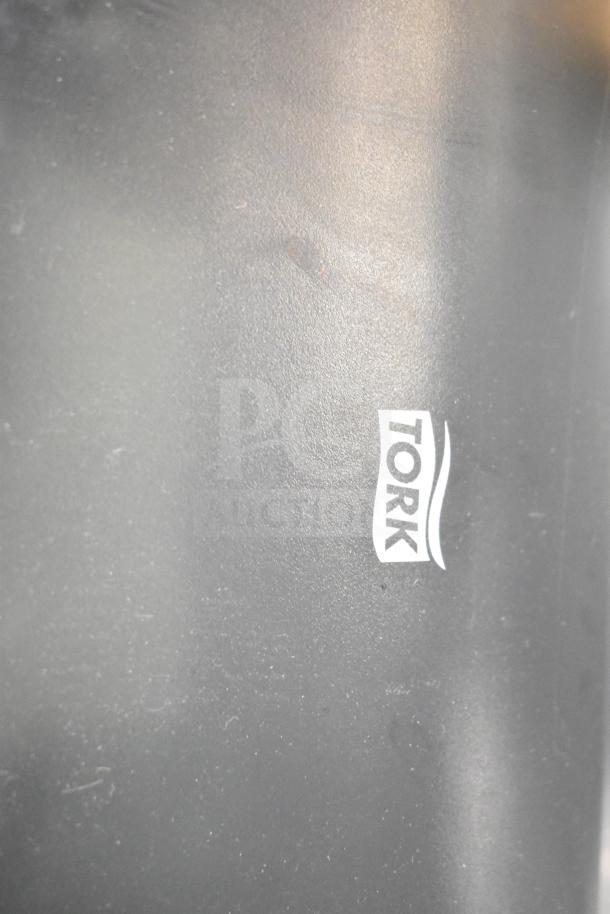 BRAND NEW Tork 772728 Black Mechanical Paper Towel Dispenser, H71. Scratch and dent condition, logo visible.