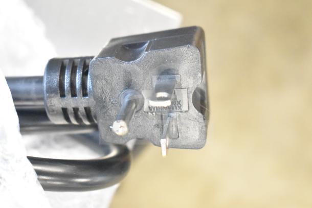 Close-up of a power plug attached to the Avantco T140 Conveyor Toaster, 120V, 1750W, showing prongs and cord details.