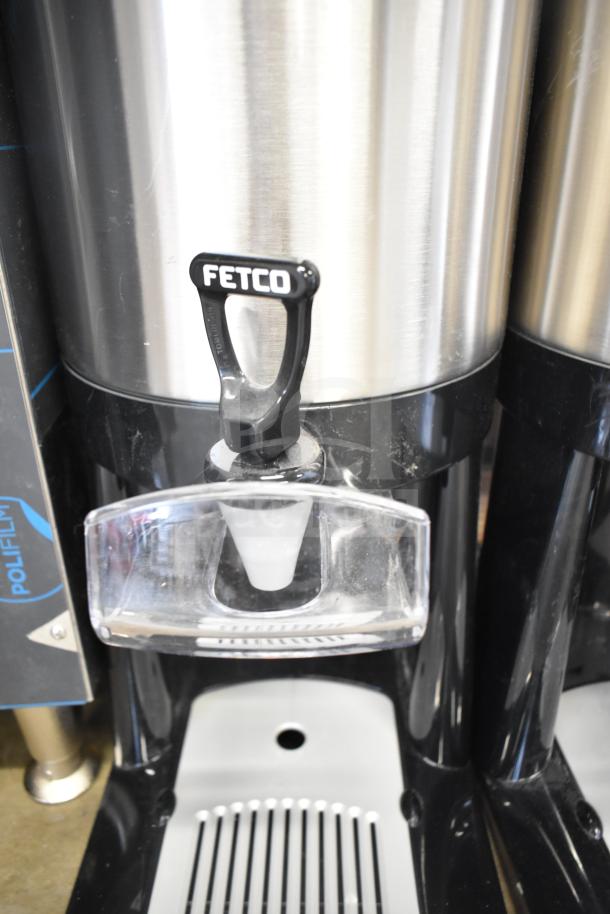 Brand new scratch and dent Fetco L4D-20 Luxus 2-gallon stainless steel coffee server with stand, spout visible.