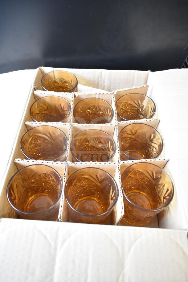 Box of 12 Libbey Hobstar 12 oz. Topaz Rocks Glasses, unused, patterned with geometric design, amber color.