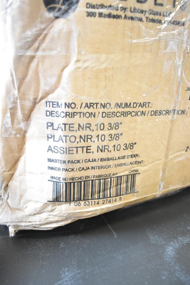 Damaged cardboard packaging showing item details. Contains Libbey 10 3/8" porcelain plates, item no. 06 63114 27414 8, made in China.