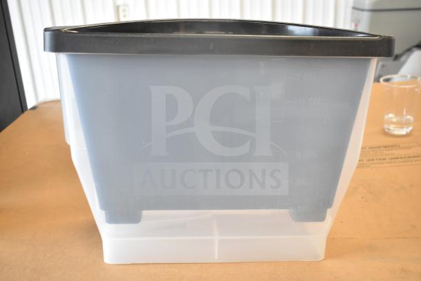 Black plastic lid on a clear container, marked with gallon measurements, likely part of a 3-gallon beverage dispenser.