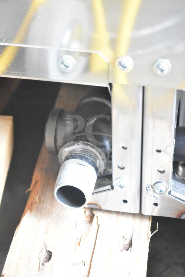 Garland 60" propane countertop griddle connection detail, showing pipe fitting and metal panel, part of scratch and dent sale.