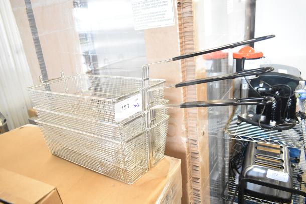 Three brand new Garland fry baskets, scratch and dent condition, stacked with black handles visible, auction tag attached.