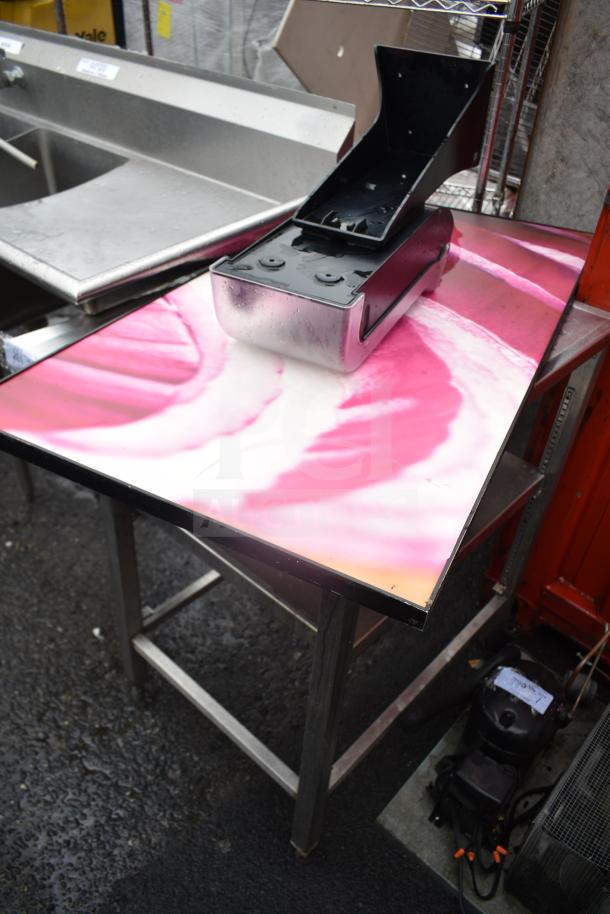 Commercial table with onion print top, featuring a small metal box. Sturdy frame, used condition.