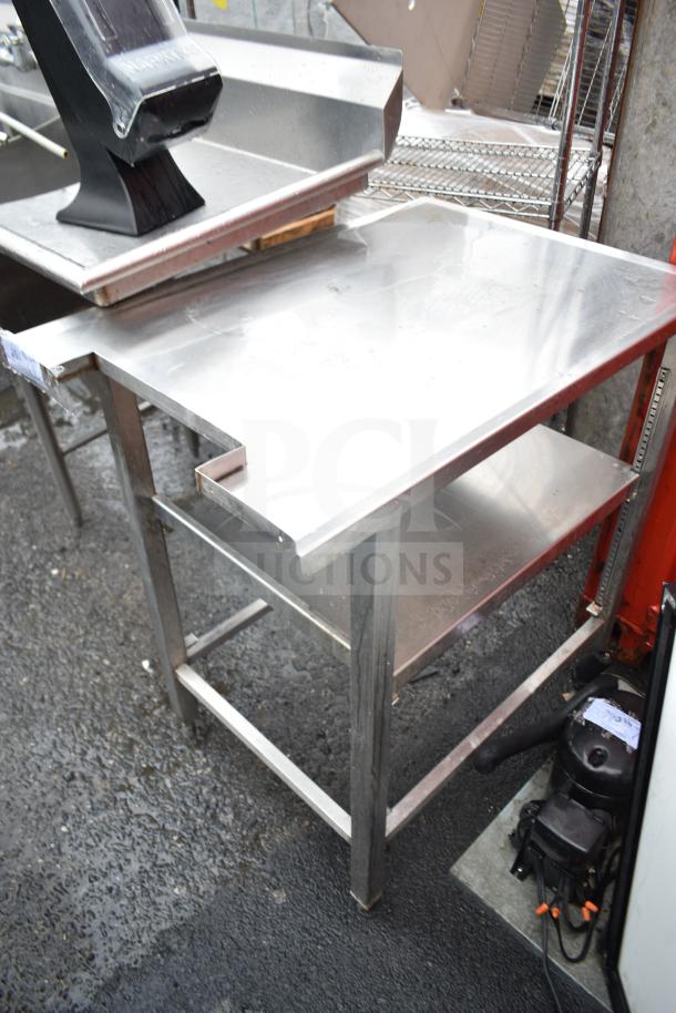 Commercial stainless steel table with attached contents, featuring durable construction and shelving underneath, in good condition.