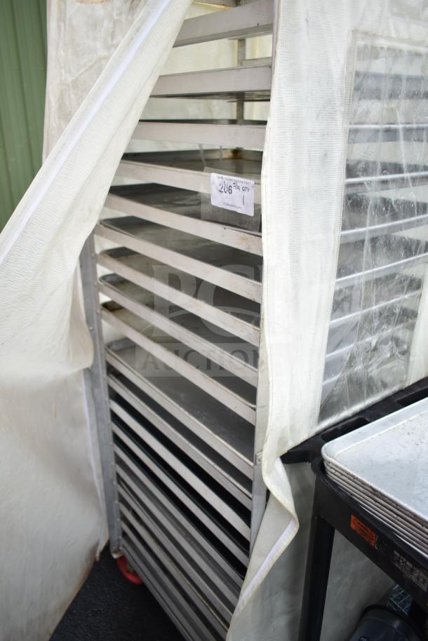 Pan transport rack with multiple baking pans, covered by a protective sheet. Shows signs of use. Auction tag visible.