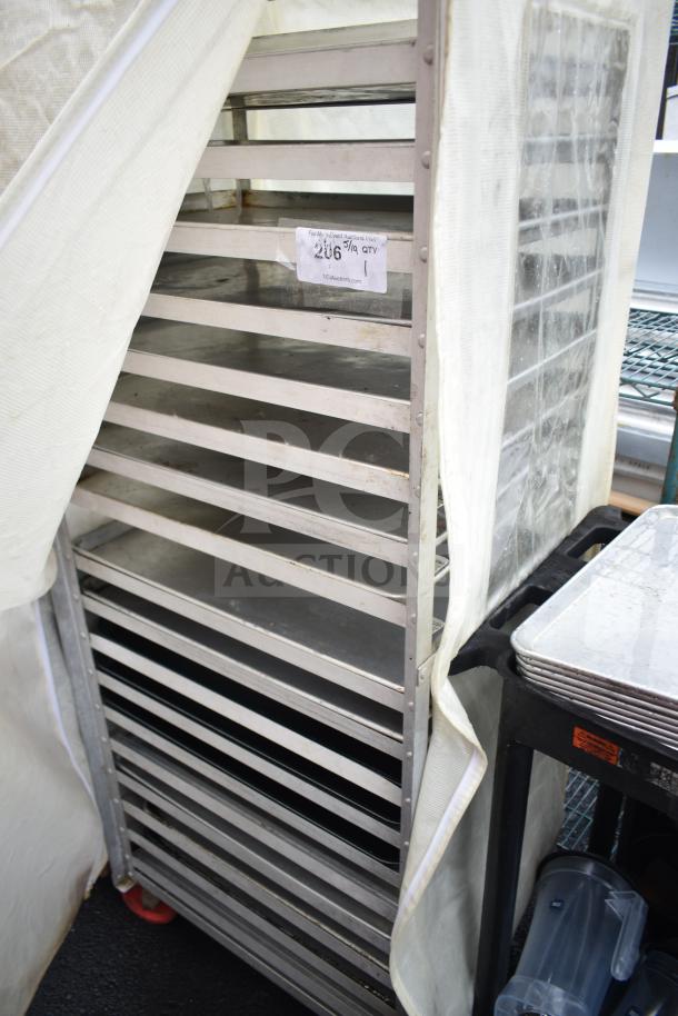 Pan transport rack with multiple shelves, baking pans, and a protective cover. Appears in used condition with auction tag.