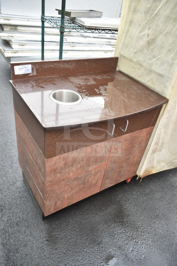 Brown counter with trash deposit hole, featuring two doors and metal handles. Ideal for efficient waste management.
